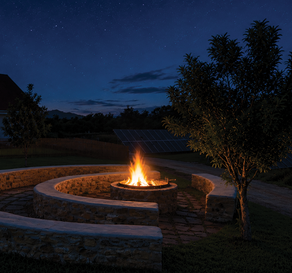 A fire burns in a circular stone fire pit surrounded by curved stone seating walls with two trees nearby under a starry night sky. Description generated by AI